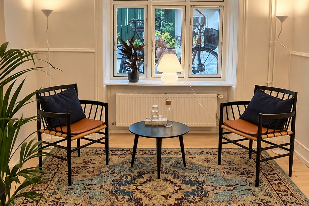 Terapirummet i klinikken på Århusgade 2, Østerbro — to stole ved et lille bord foran vinduet